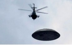 Three black helicopters are seen near to a UFO as it hovers over Los Angeles