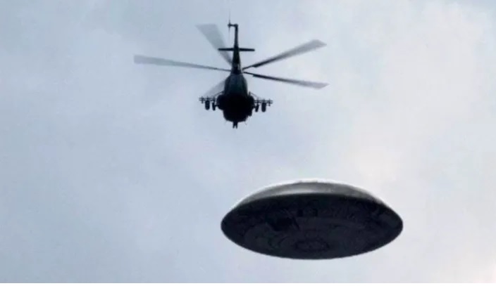 Three black helicopters are seen near to a UFO as it hovers over Los Angeles