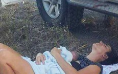 On the side of a busy highway, a mother gives birth to her daughter in the front seat of her automobile.