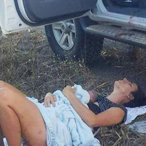On the side of a busy highway, a mother gives birth to her daughter in the front seat of her automobile.
