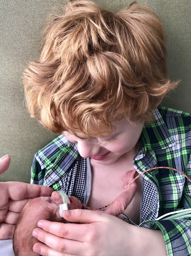 The moving image of a 6-year-old brother holding his premature infant sibling.